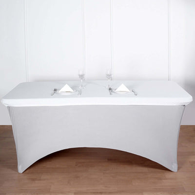 Grey table cover draped on a table set for dining with glasses and napkins.