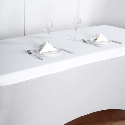 Elegant table setting with napkins, glasses, and cutlery on a white tablecloth.