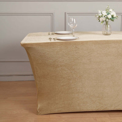 Elegant gold table cover draped over a table with dinnerware and floral centerpiece.