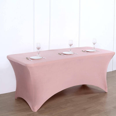 Pink fitted table cover with plates and glasses set for dining.