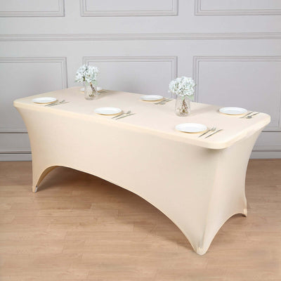 Beige table cover with plates and floral centerpieces