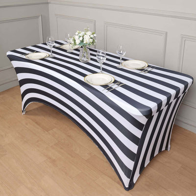 Black and white striped table cover on a table with plates and glasses.