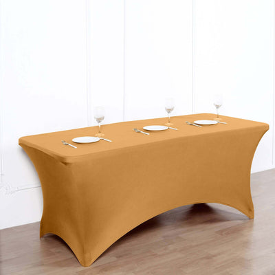 Orange table cover draped over a table with plates and glasses set.
