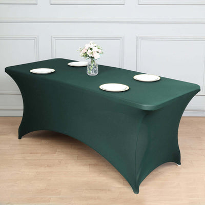 Green fitted table cover with plates and vase, styled for an event setting.