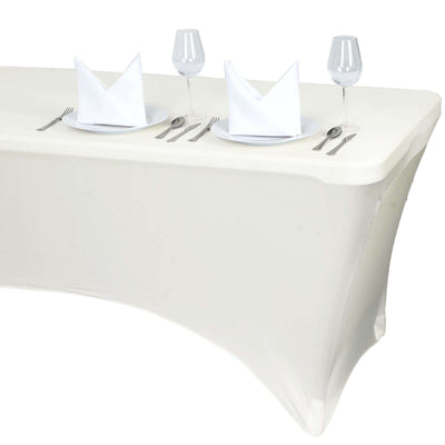 White table set with plates, glasses, and folded napkins for dining.
