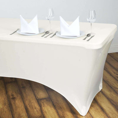 Elegant white table setup with plates, glasses, and napkins for dining.