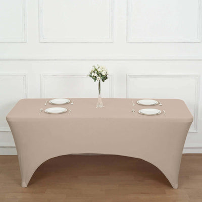 Beige table cover with plates and a vase of flowers on a styled dining table.