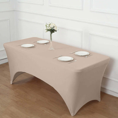 Beige fitted table cover with plates and cutlery arranged elegantly.