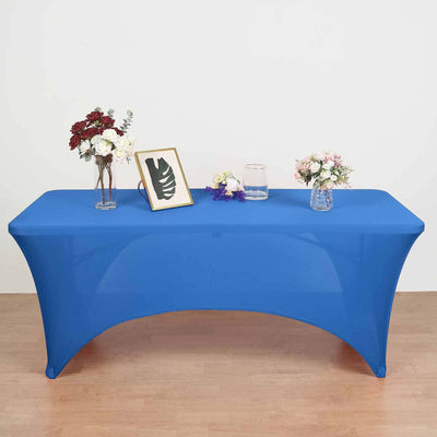 Blue table cover on a display table with floral arrangements and decor items.