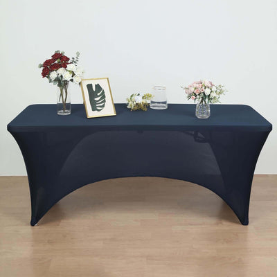Navy stretch table cover on a modern table with floral arrangements and decor.