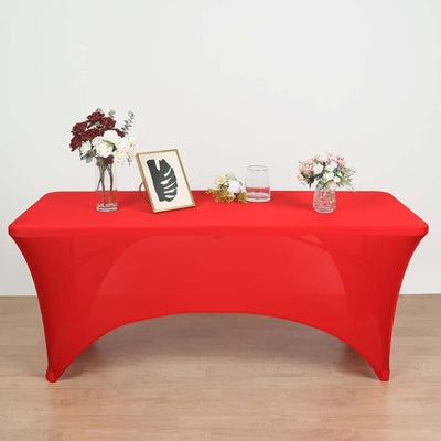 Red table with floral arrangements and picture frame on top.