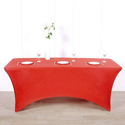 Red table cover draped over a table set for a dining arrangement.
