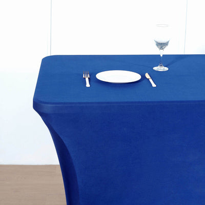 Blue tablecloth draped over a table with plate and glass setup.