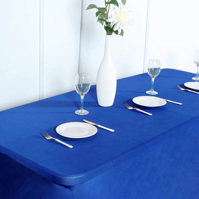 Blue tablecloth with white plates and glasses set for a dining table.