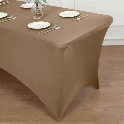 Brown fitted tablecloth on a dining table with plates and utensils.