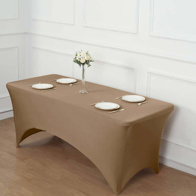 Brown table cover with white plates and a vase of flowers on a wooden floor.