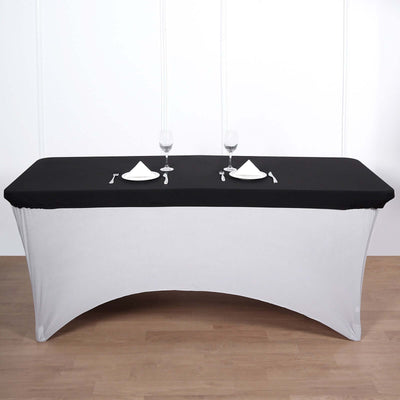Elegant black and white table setup with dinnerware and glasses.