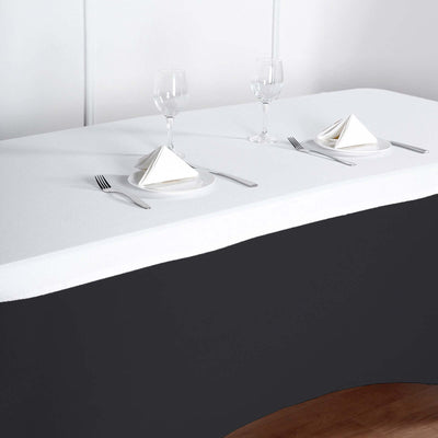 Elegant dining table setup with folded napkins and glassware.