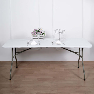 Folding banquet table set for dining with decorative centerpiece and tableware.