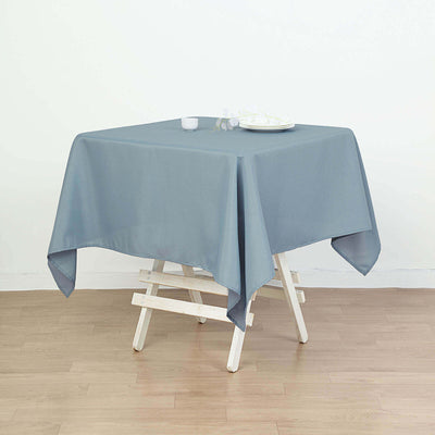Gray tablecloth draped over a wooden table in a minimalist setting.