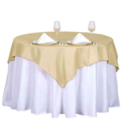 Elegant gold table cover with white linen, set for two with wine glasses and napkins.