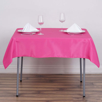 Pink tablecloth set with glassware and napkins on a dining table.