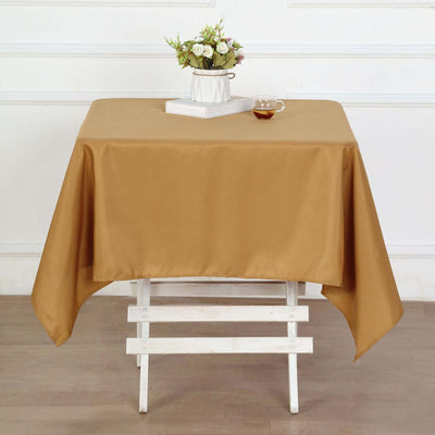 Brown tablecloth draped over a white table with a vase and cup on top.