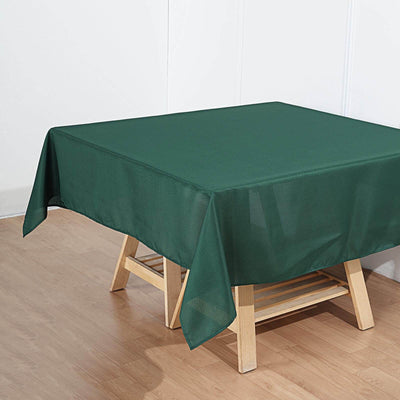 Green tablecloth draped over a wooden table in a simple setting.
