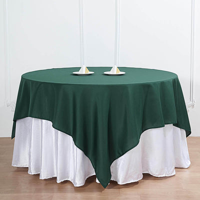 Green round tablecloth draped elegantly over a white table.