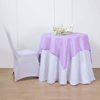 Purple tablecloth draped over a white table with a floral centerpiece.