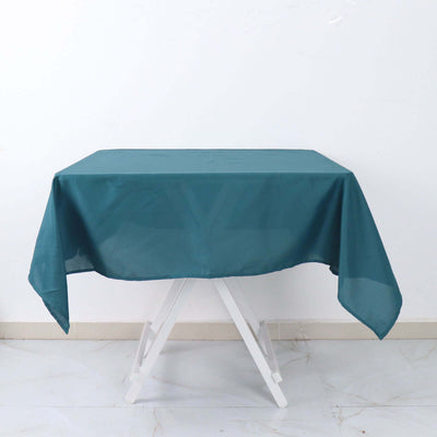 Teal tablecloth draped over a white folding table