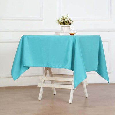 Turquoise tablecloth draped on a wooden table in a bright, staged setting.