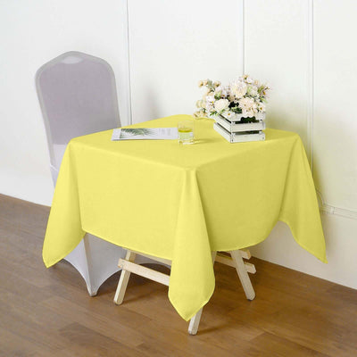 Yellow tablecloth draped over a table with a chair and flowers
