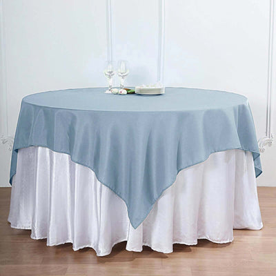 Round table with blue tablecloth and elegant dining setup.