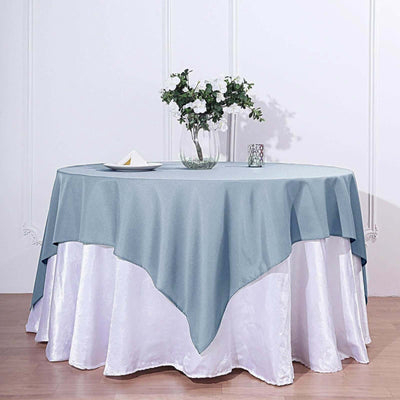 Light blue tablecloth draped over a white table with floral decor.