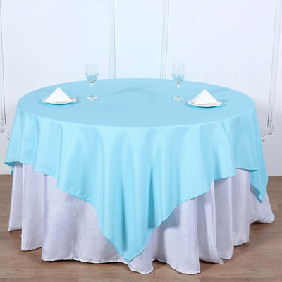 Round table set with blue tablecloth and elegant glassware.