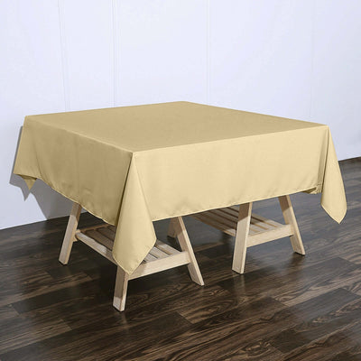 Yellow tablecloth draped over a wooden table on a dark floor.