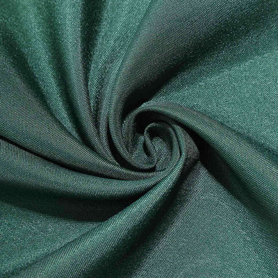 Textured dark green fabric swirl close-up shot.