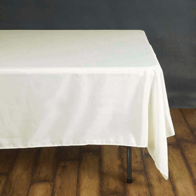 White tablecloth draped over a table with wooden floor background.
