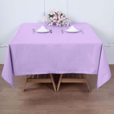 Purple tablecloth draped over a wooden table set for dining.