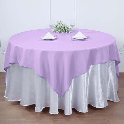 Round table with lavender tablecloth and silver underlayer, elegantly set for dining.