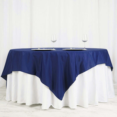 Navy blue tablecloth draped over a round table with glassware