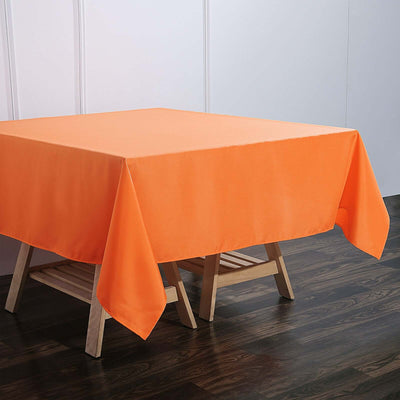 Orange tablecloth on a wooden table in a staged setting.