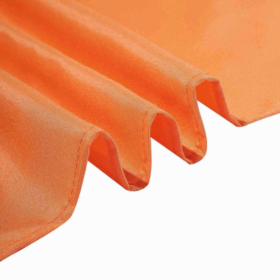 Orange fabric draping with smooth texture and crisp folds.