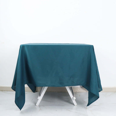 Teal tablecloth draped over a white folding table