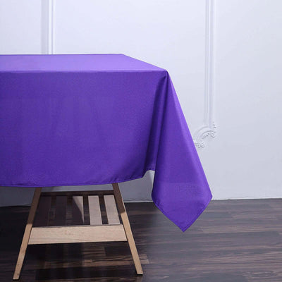 Purple tablecloth draped over a wooden table.