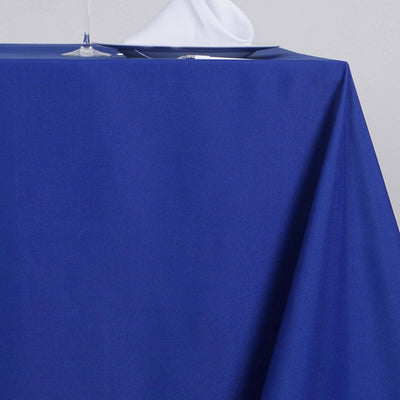 Blue tablecloth draped over a table with a glass and napkin visible.