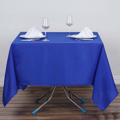 Blue tablecloth set on a table with glasses and napkins, ready for dining.