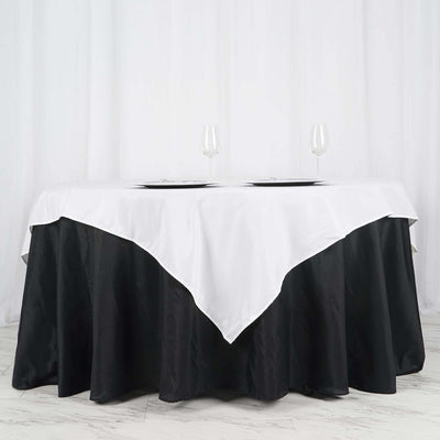 Elegant black and white tablecloth draped over a round table with glassware.