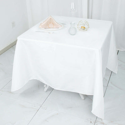 White tablecloth draped over a table in a bright, minimalist setting.